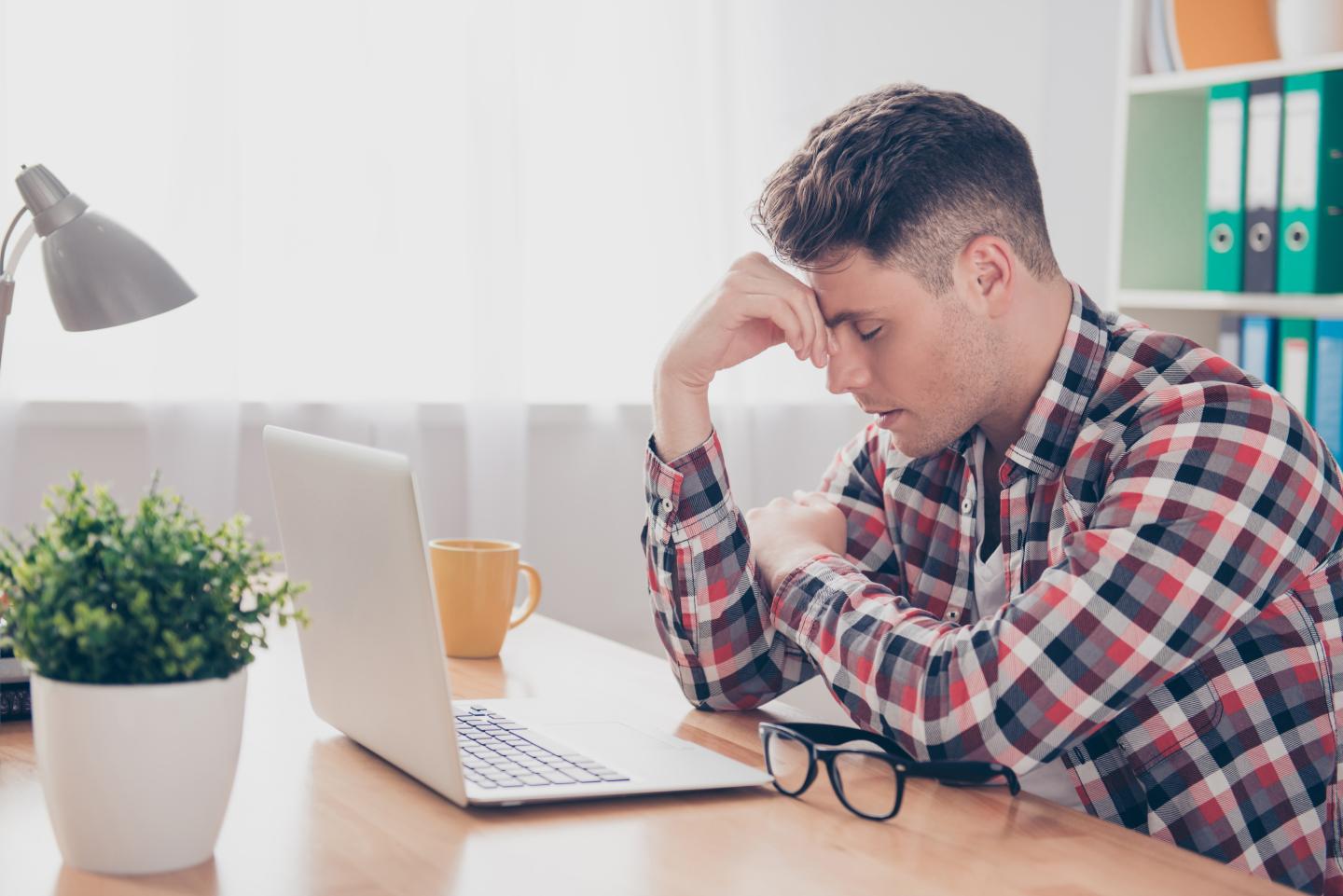 Overworked minded man having headache after working day