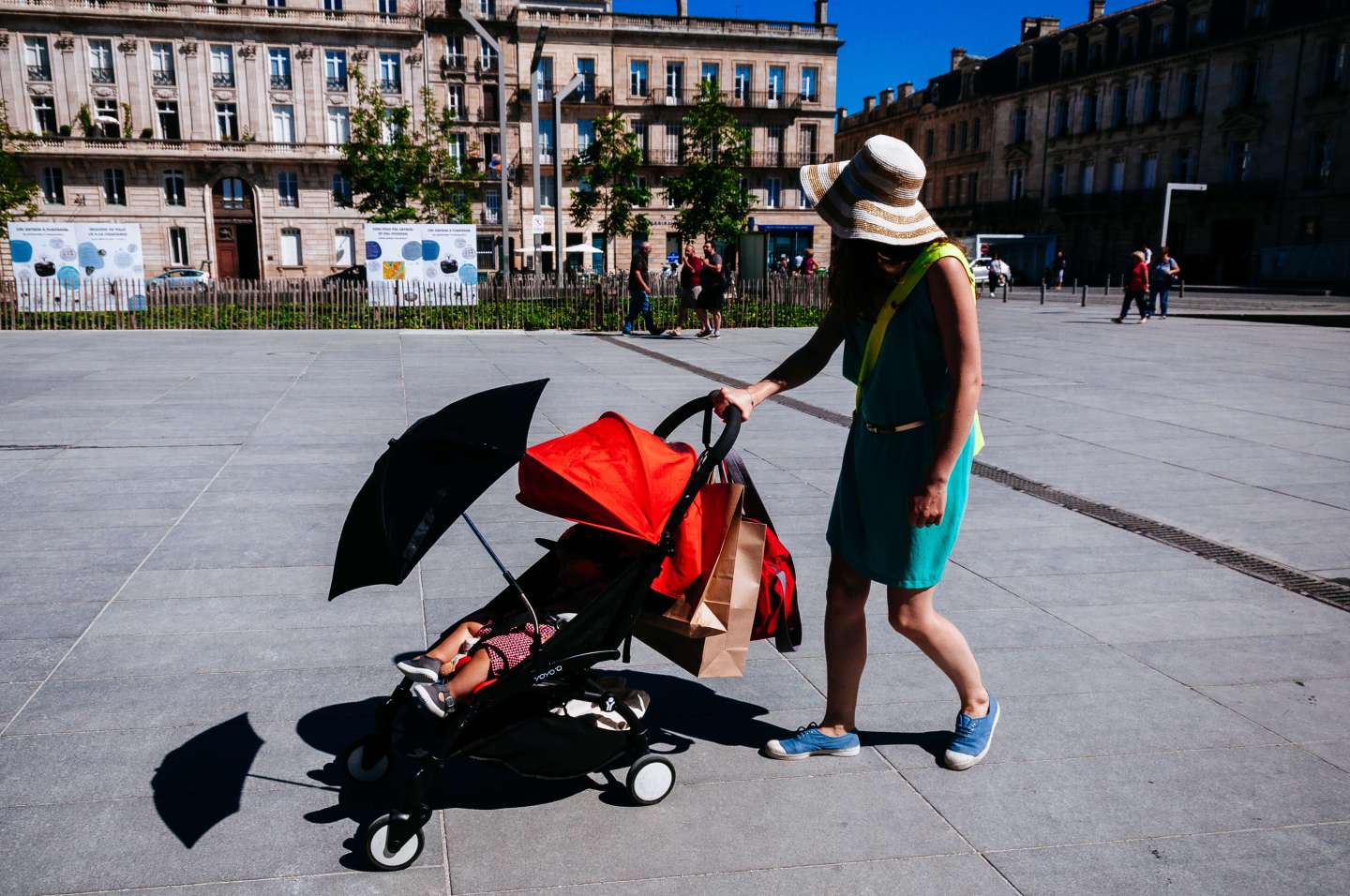 Woman pushing baby carriage on the street