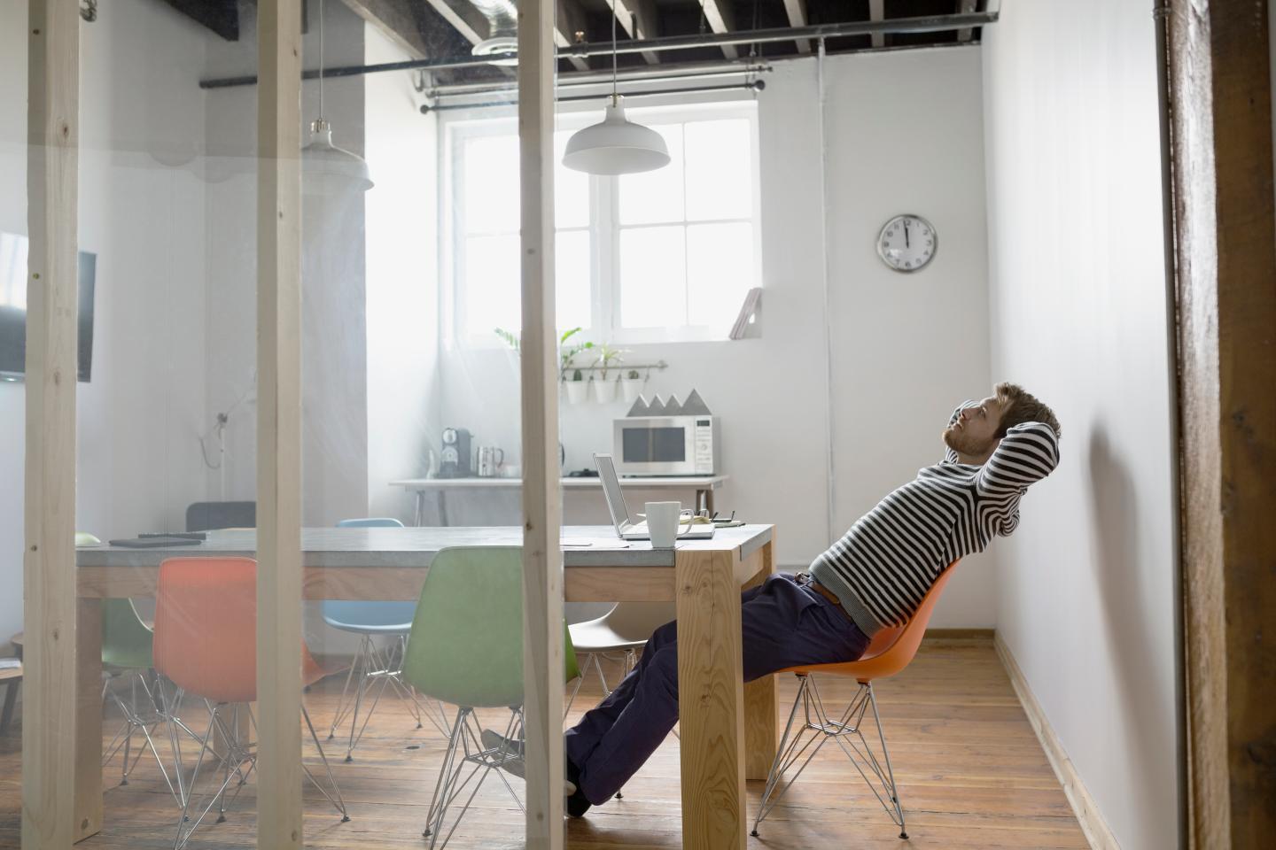 Businessman leaning back in chair in office
