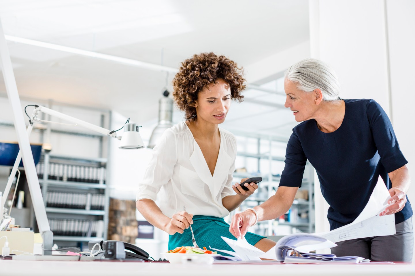Businesswomen eating and working