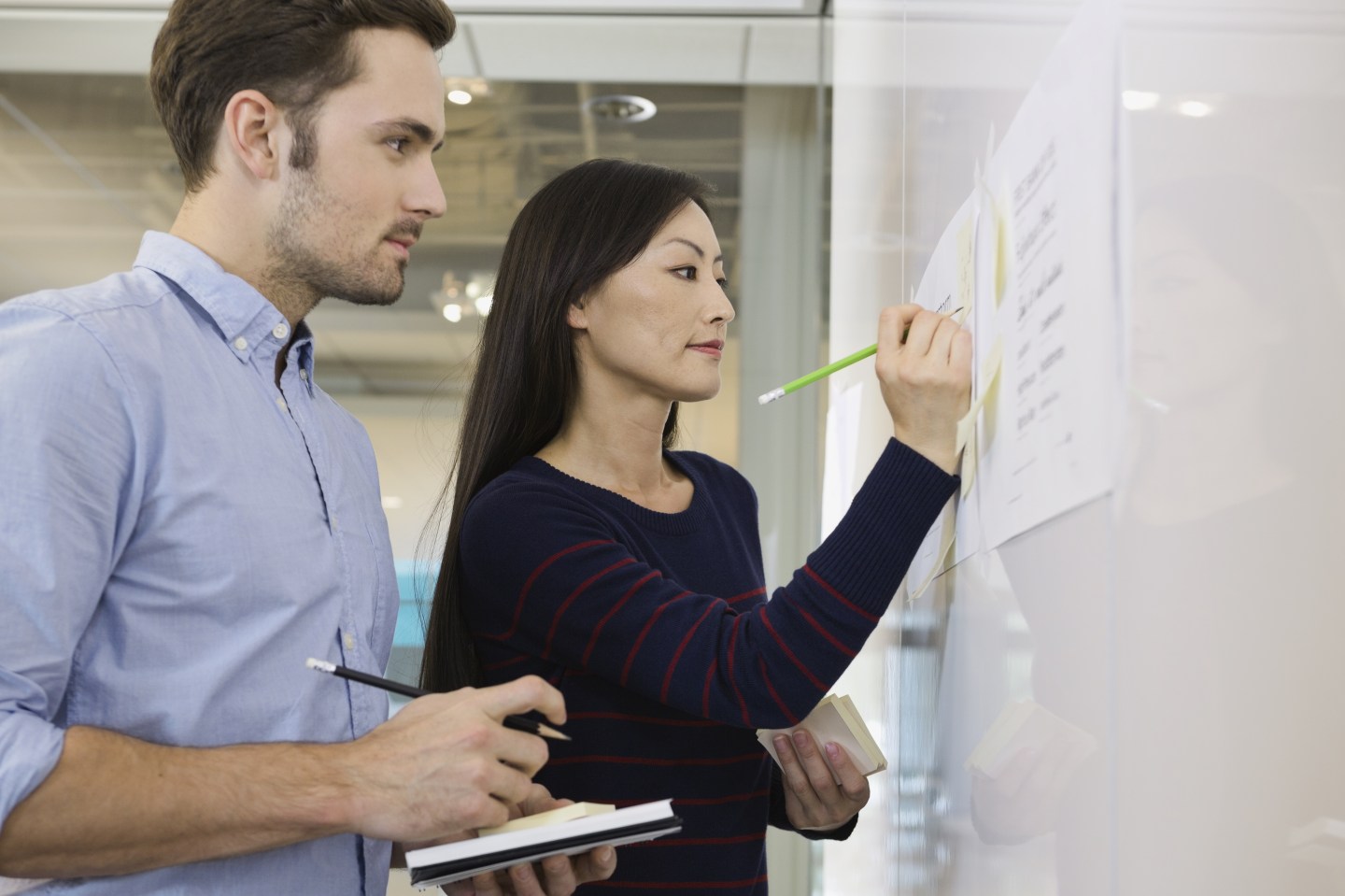 Business people writing notes on whiteboard
