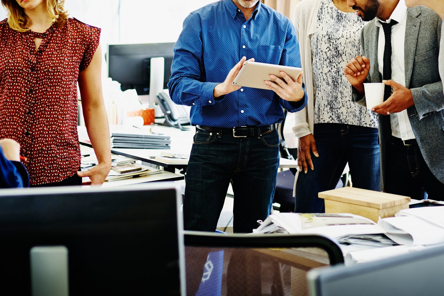 Coworkers discussing project on digital tablet