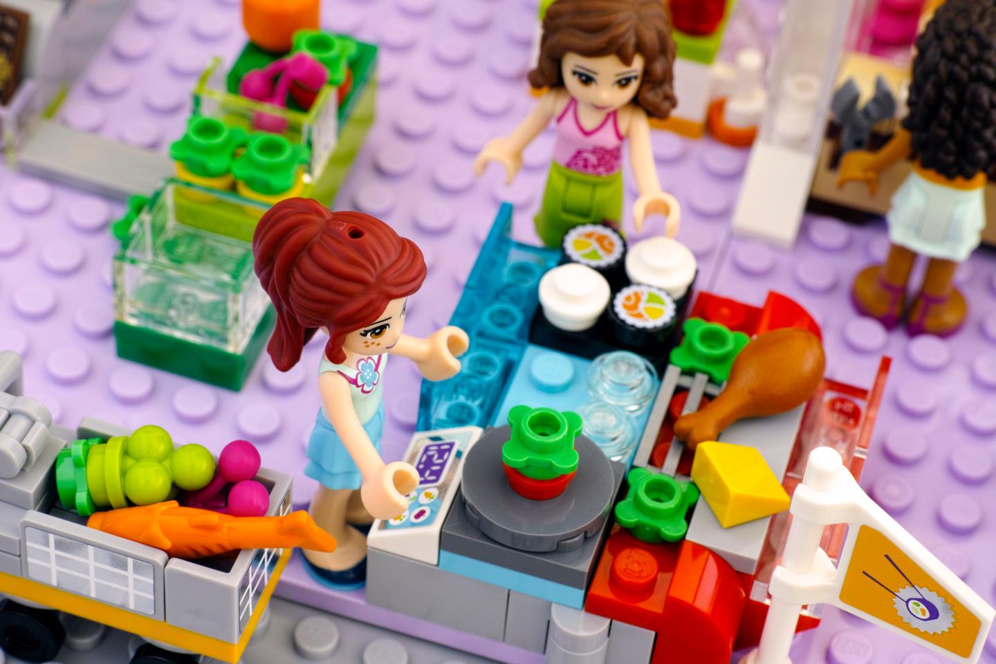 Lego girl in supermarket weighing vegetables
