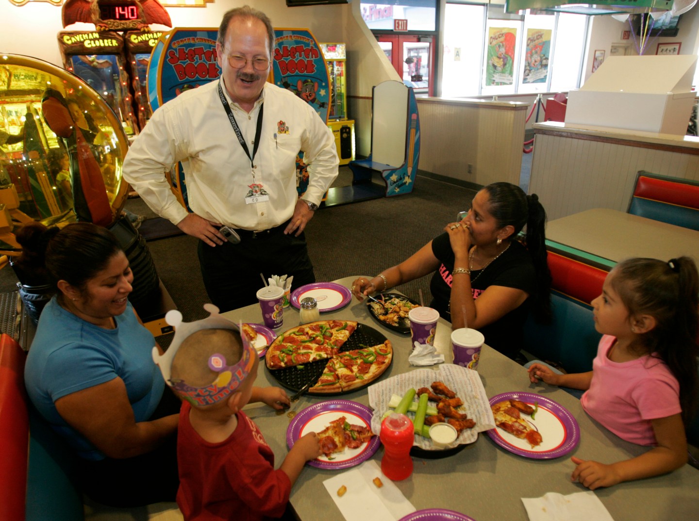 Ed Porter, Area Director for Chuck E. Cheese, chats with a family having a birthday party. This sto