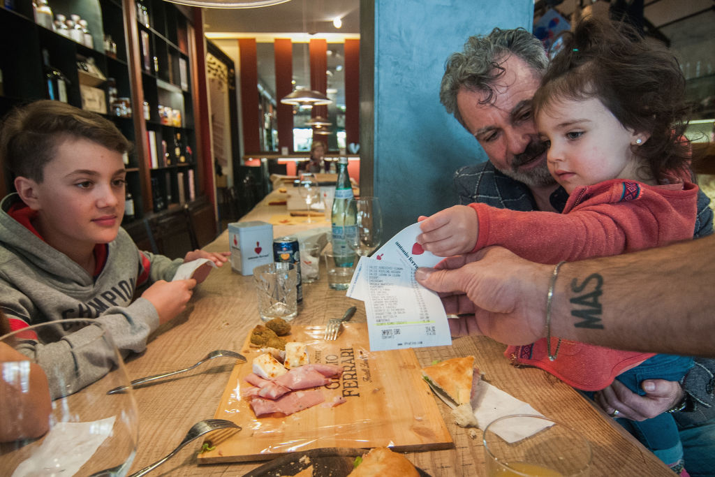 A family receives the bill with the 5% discount for the kids' good behavior in the Antonio Ferrari restaurant on Feb. 15, 2017, in Padua, Italy.