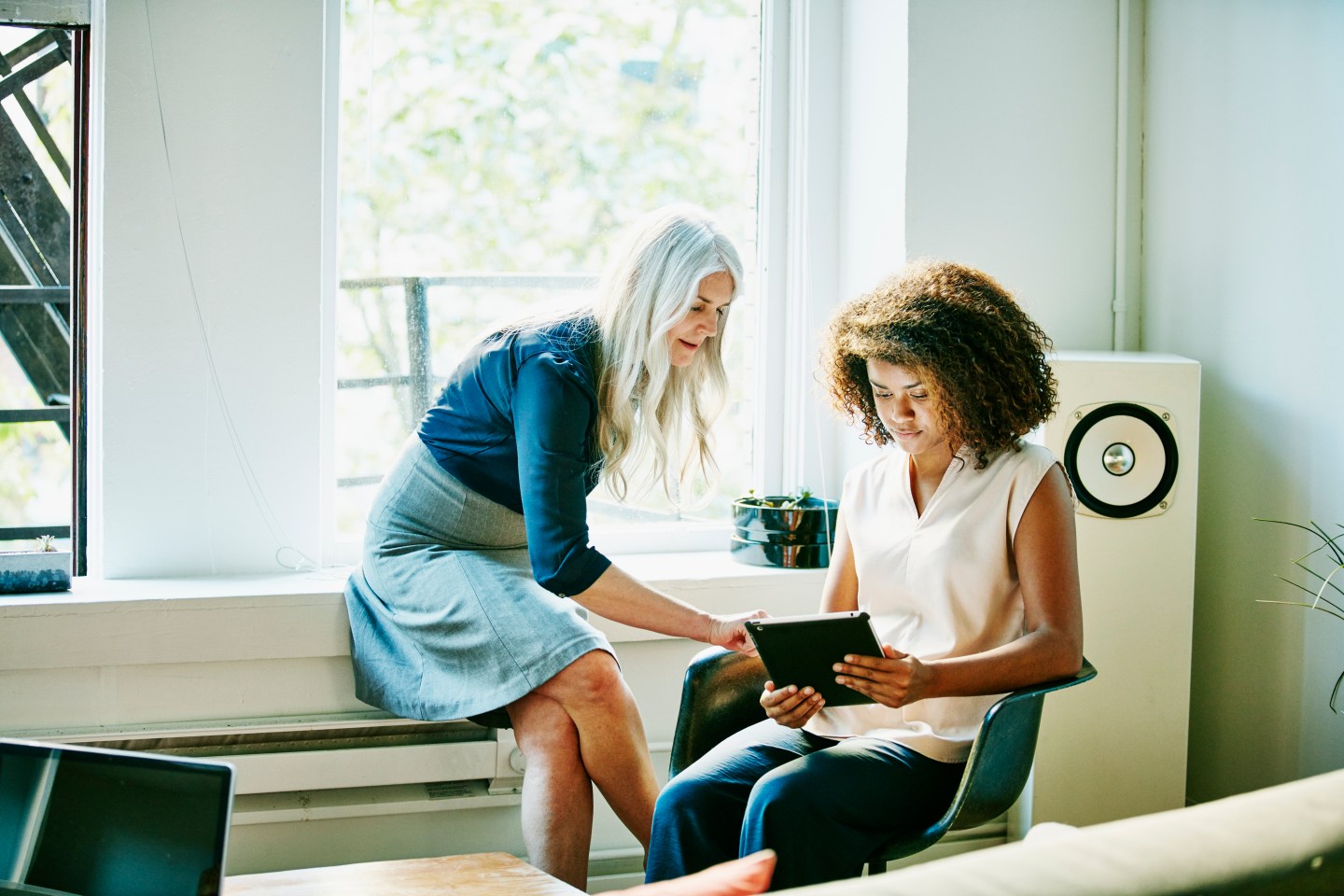 Businesswomen discussing project on digital tablet
