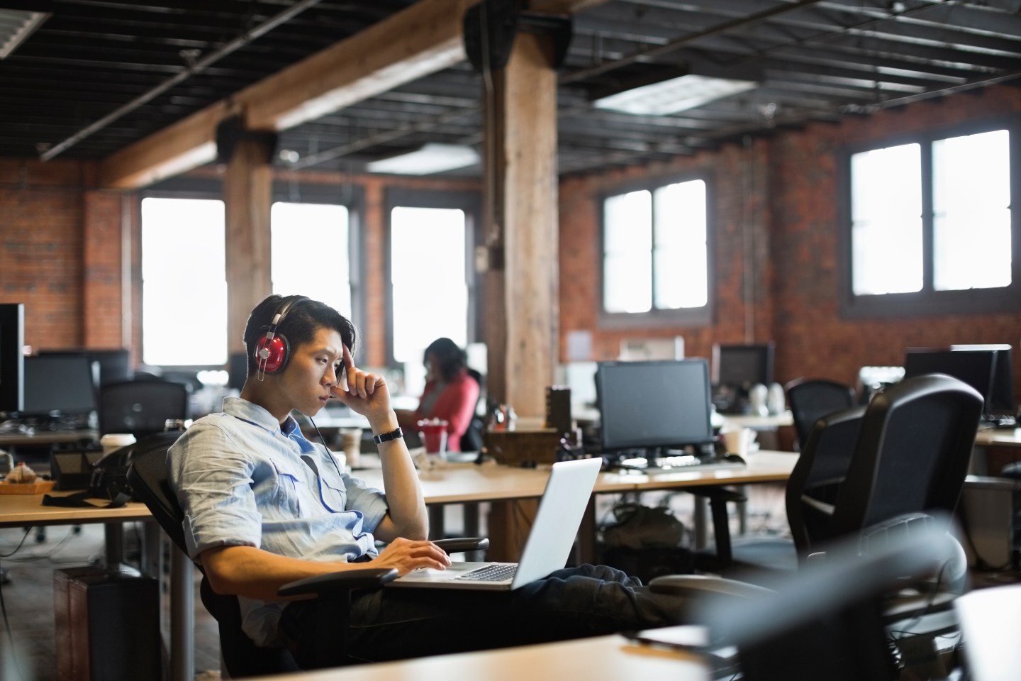 Entrepreneur working on laptop in creative office space