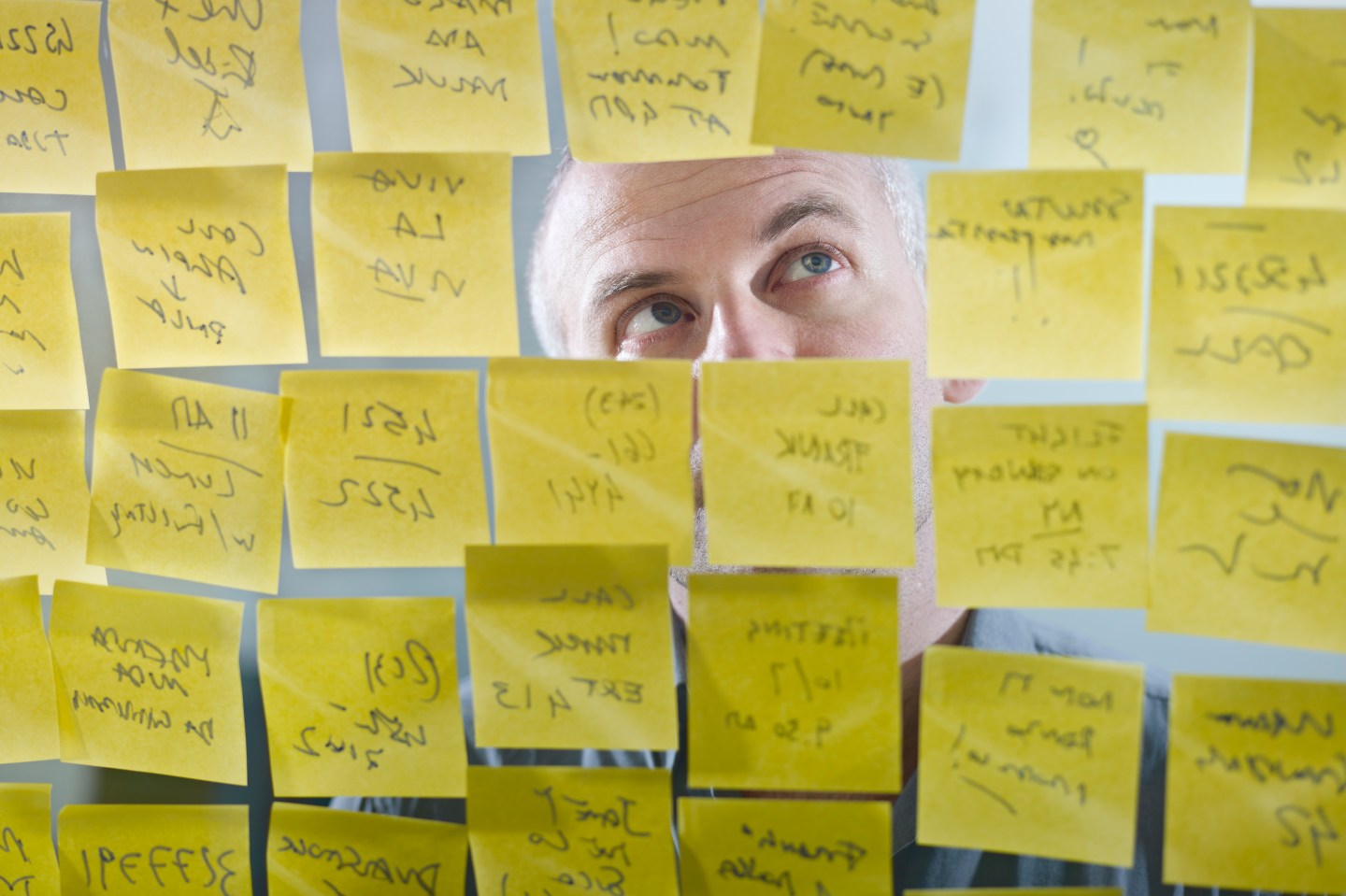 Caucasian businessman looking at adhesive notes on wall