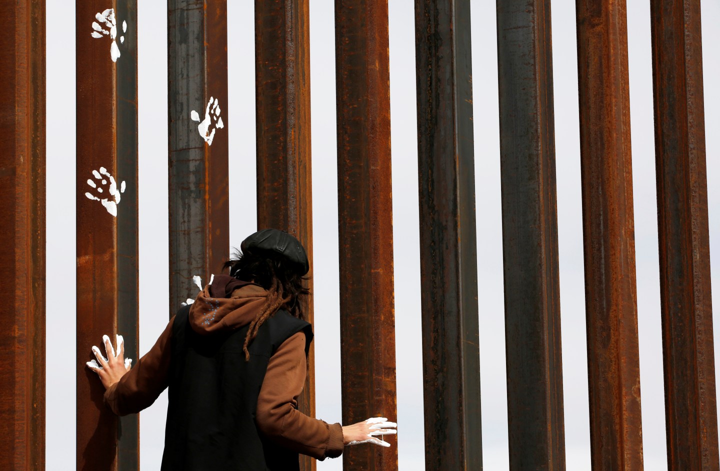 Activist paints the U.S.-Mexico border wall between Ciudad Juarez and New Mexico as a symbol of protest against U.S. President Donald Trump's new immigration reform in Ciudad Juarez, Mexico