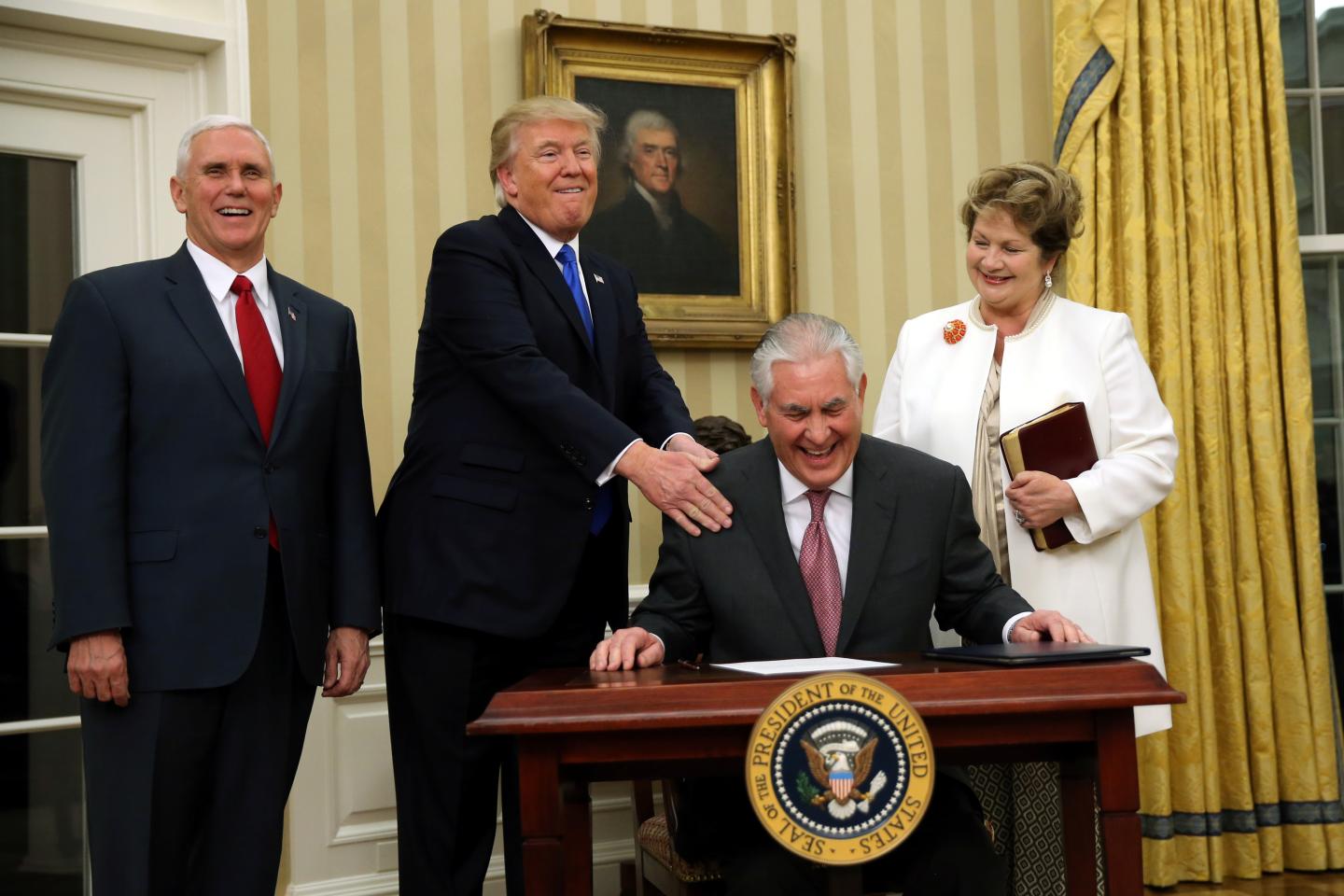 U.S. President Donald Trump reacts during the swearing in ceremony for new U.S. Secretary of State Rex Tillerson, accompanied by his wife Renda St. Clair and Vice President Mike Pence at the Oval Office of the White House in Washington, DC