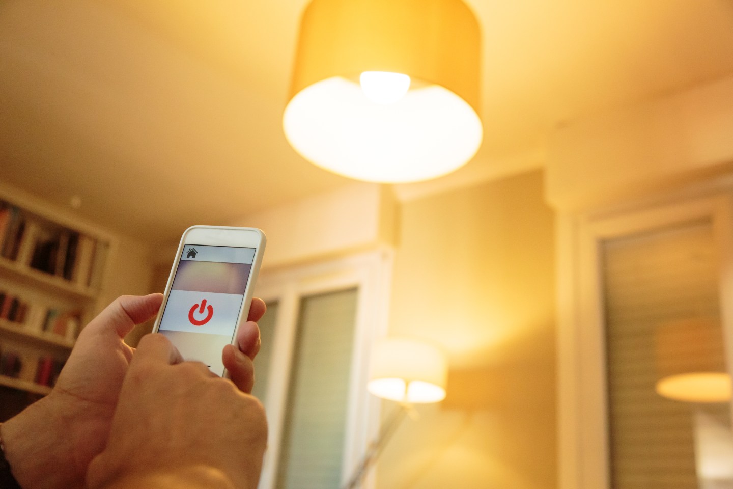 Smart home: man controlling lights with app on his phone