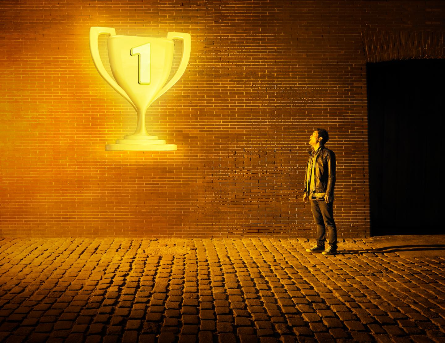 young man looking at glowing tropy