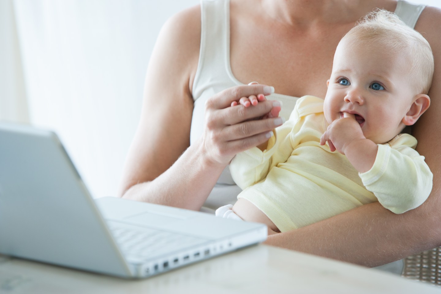 Woman holding baby at computer