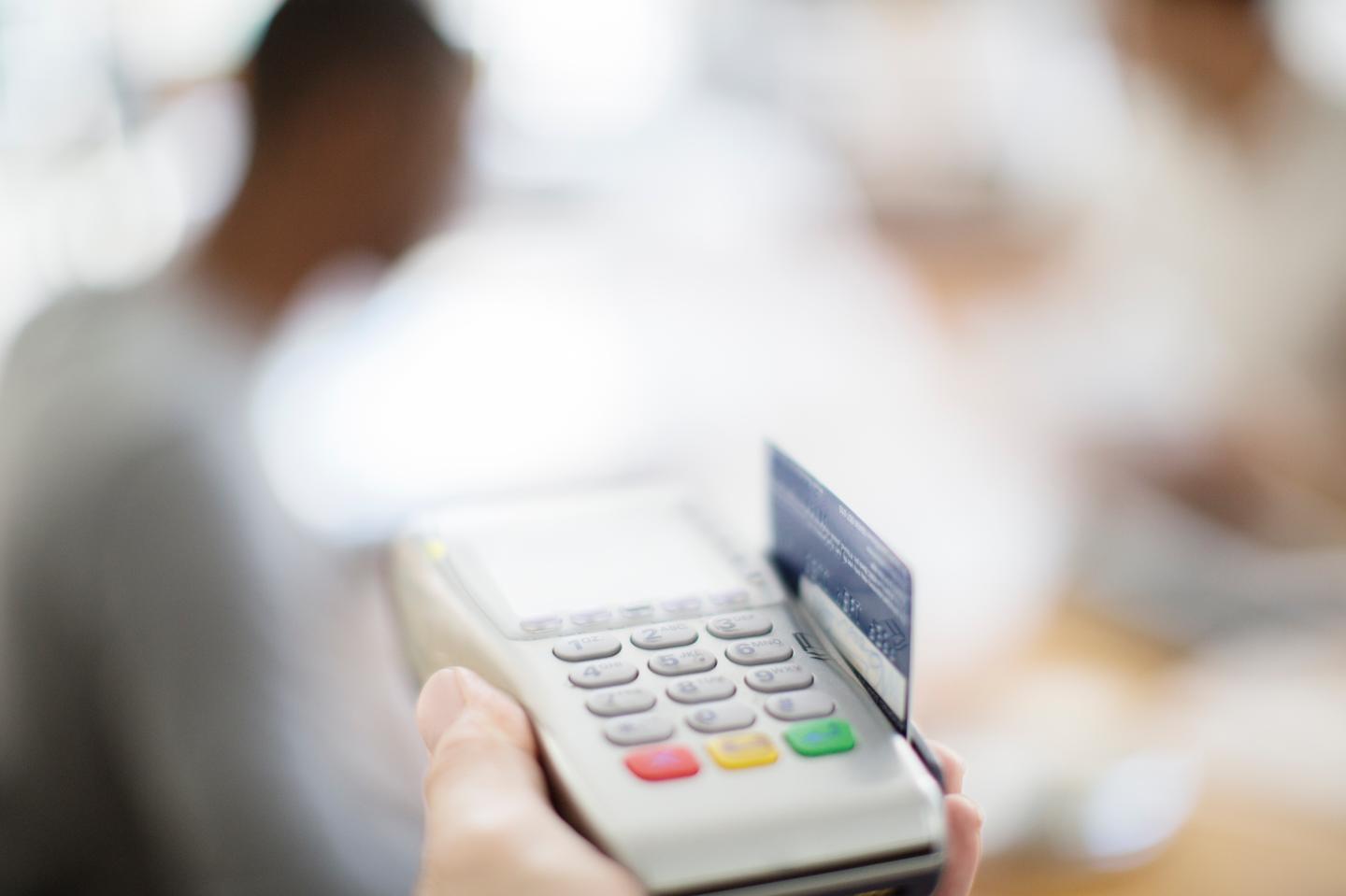 Credit card being swiped through payment machine