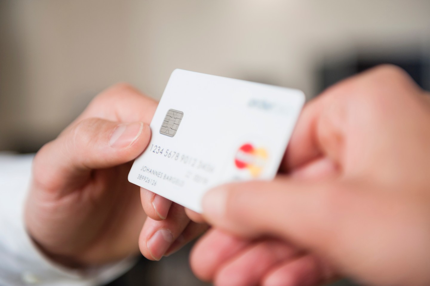 Man passing credit card to woman, close-up