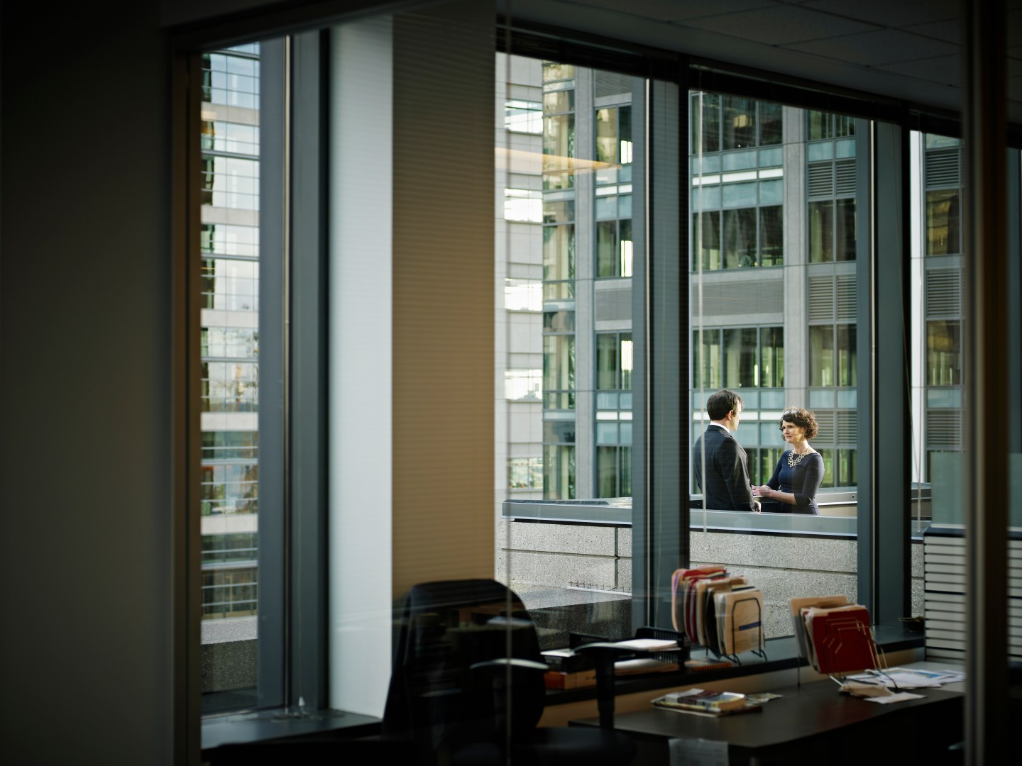 Coworkers in discussion on deck of office