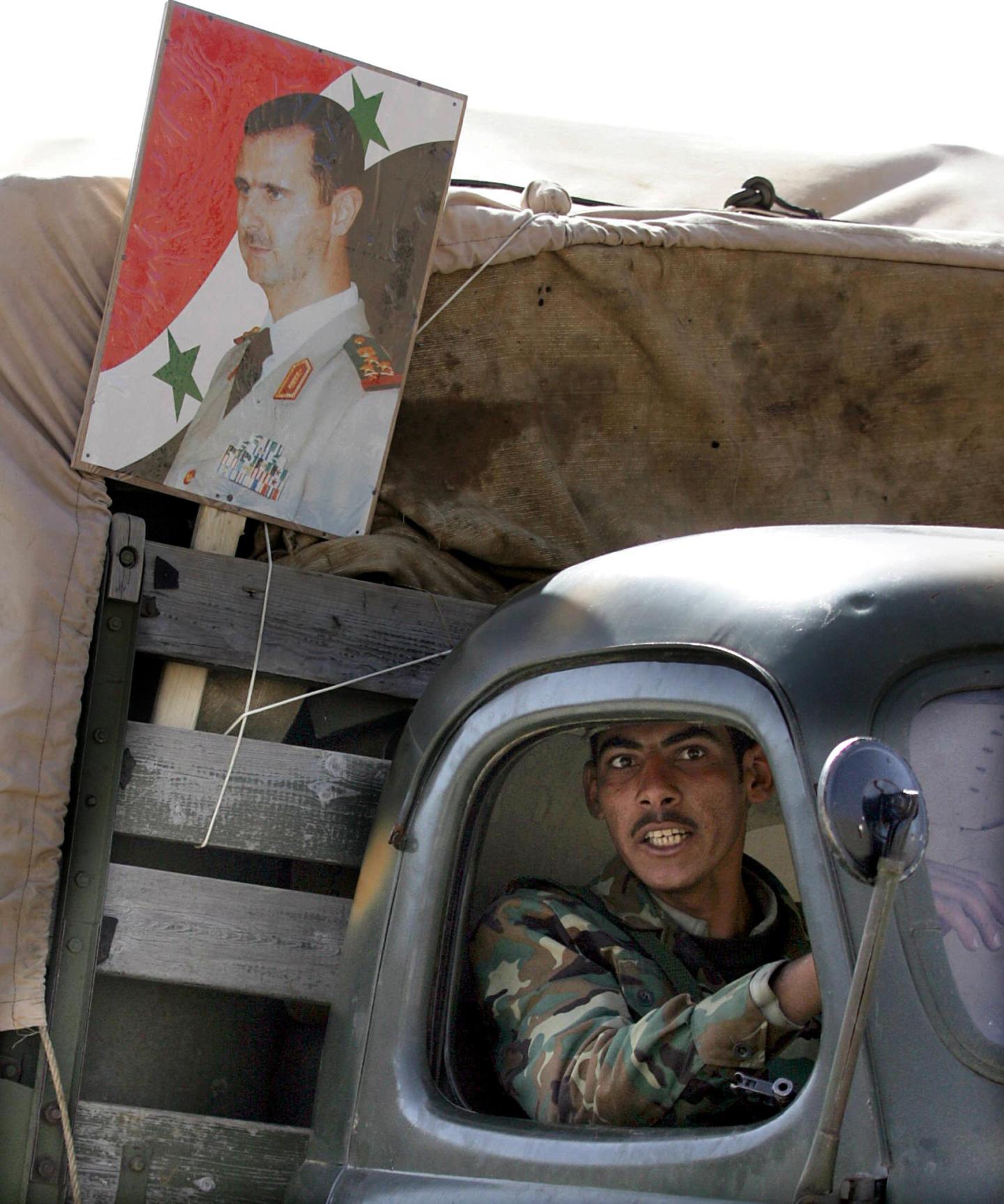 A Syrian soldier sits in a truck, decora