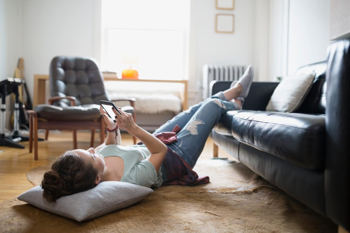 Woman laying with feet up texting