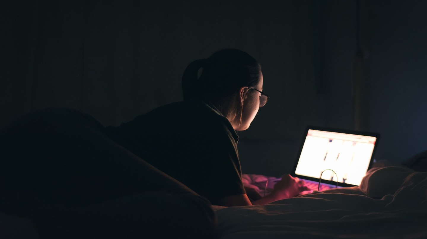 Woman using laptop in bed