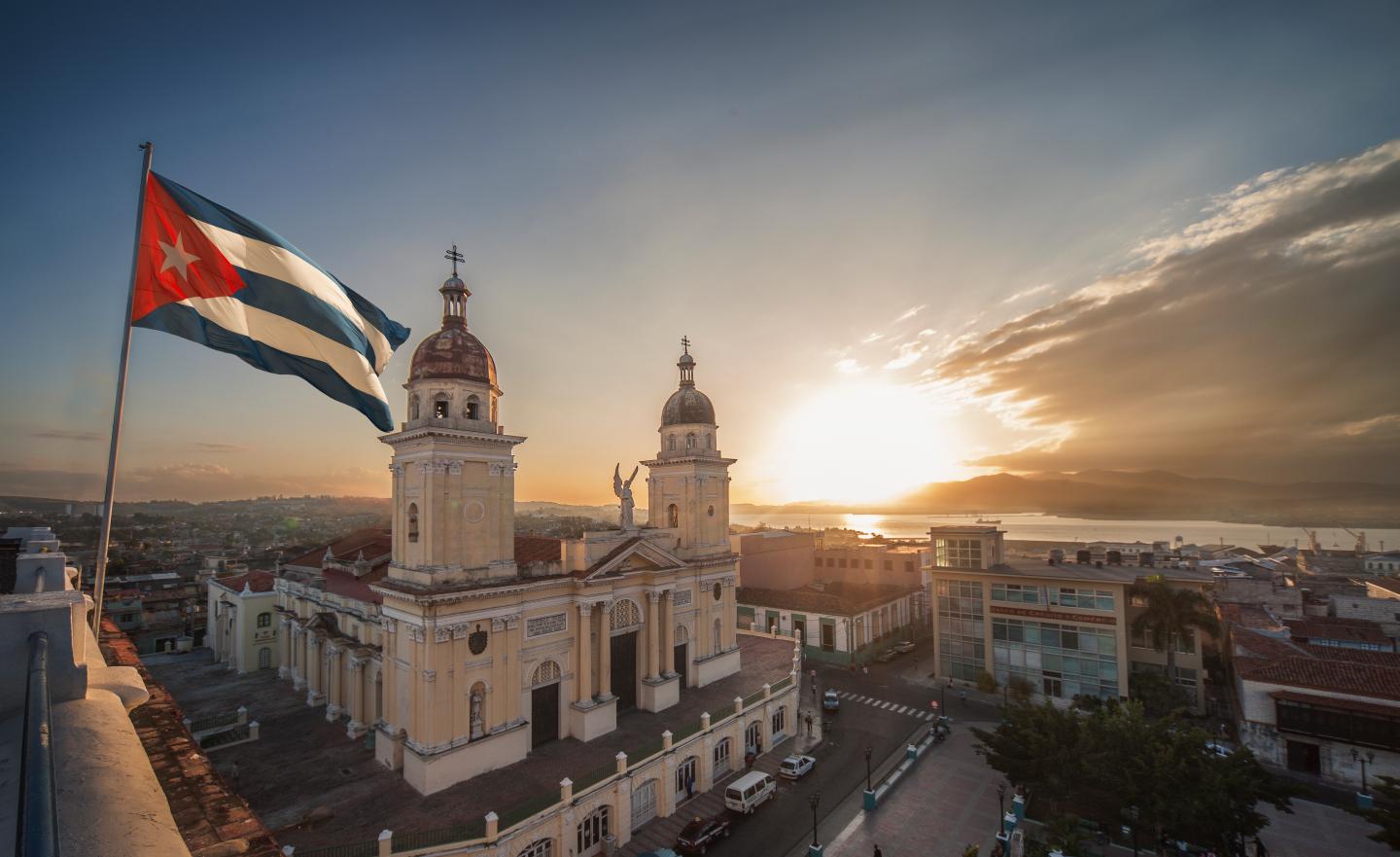 Cuban flag over Plaza de la Cathedral at sunset, Santiago de Cuba, Cuba