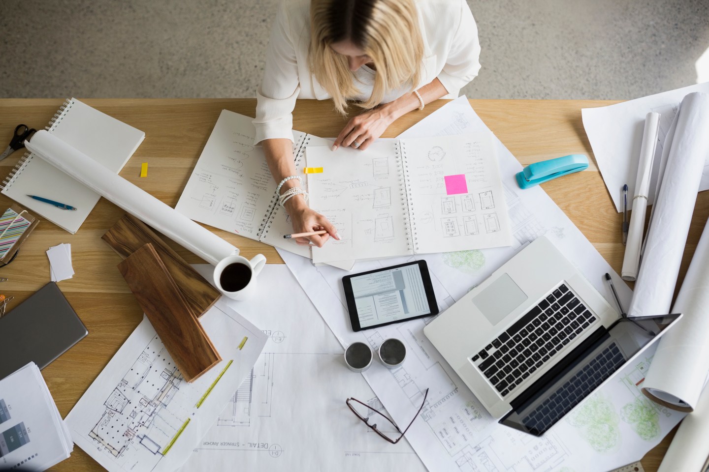 Overhead view architect drafting blueprints at table