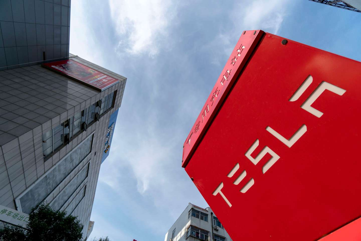 A vacant Tesla charging station on a parking lot beside a
