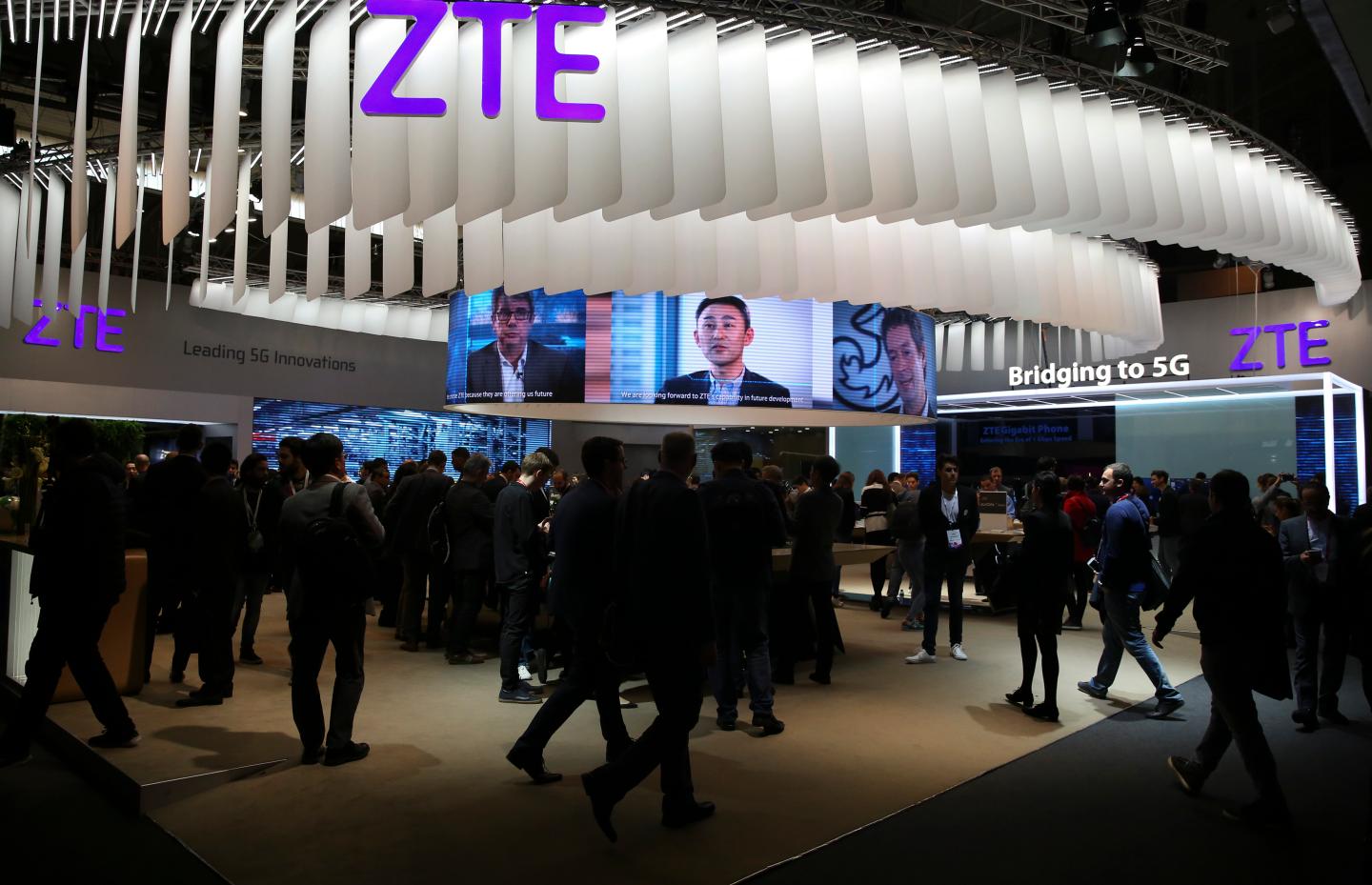 People stand at ZTE's booth during Mobile World Congress in Barcelona