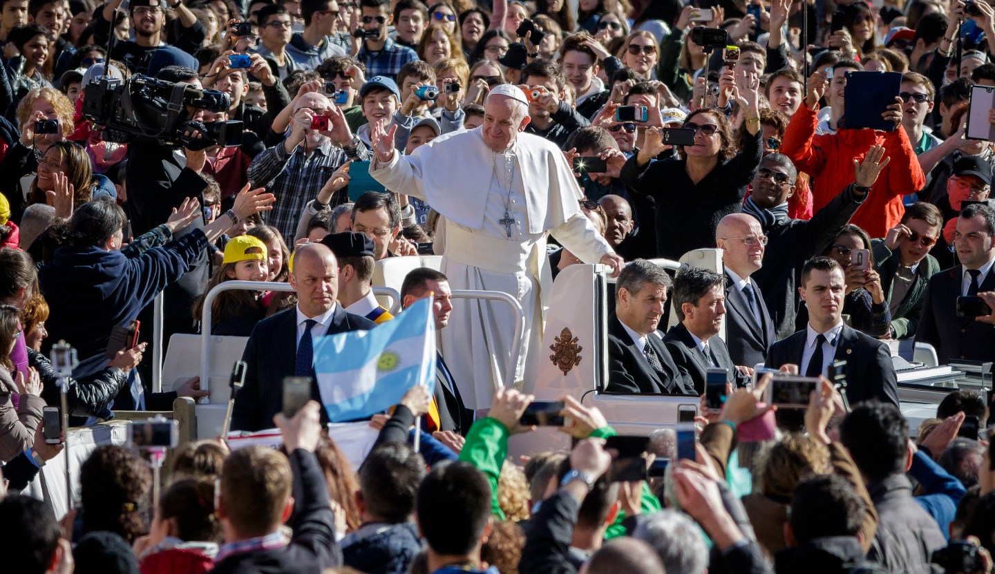 Pope Francis rides on the Popemobile through the crowd of