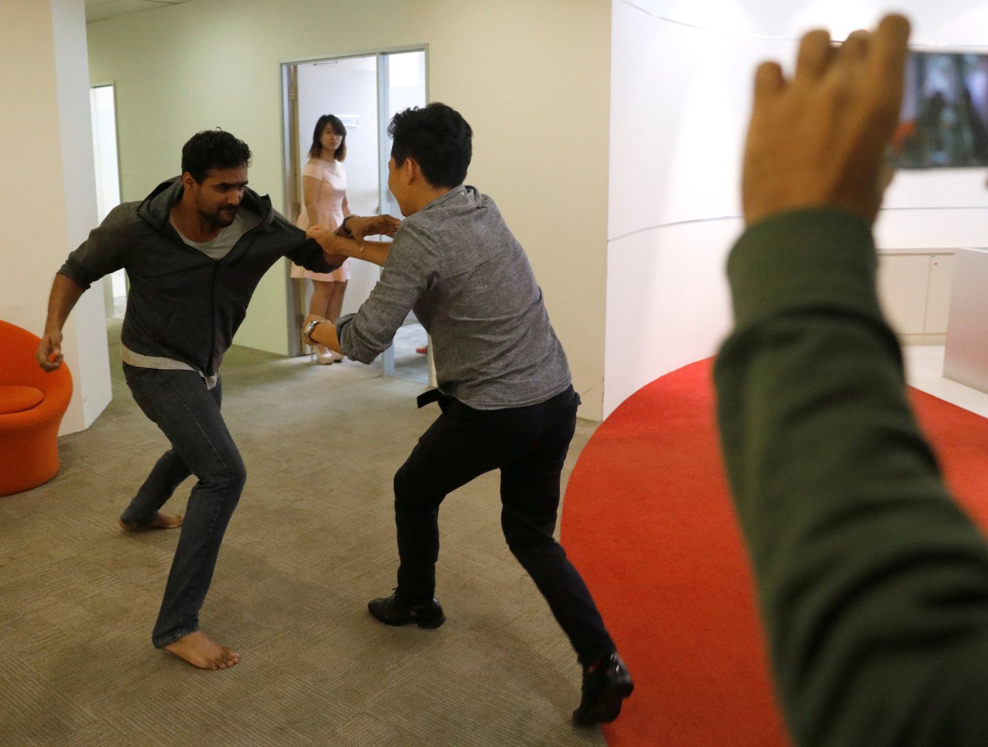 Graymatics employees pretend to fight as they record footage to be used to "train" their software to watch and filter internet videos for violence, at their office in Singapore