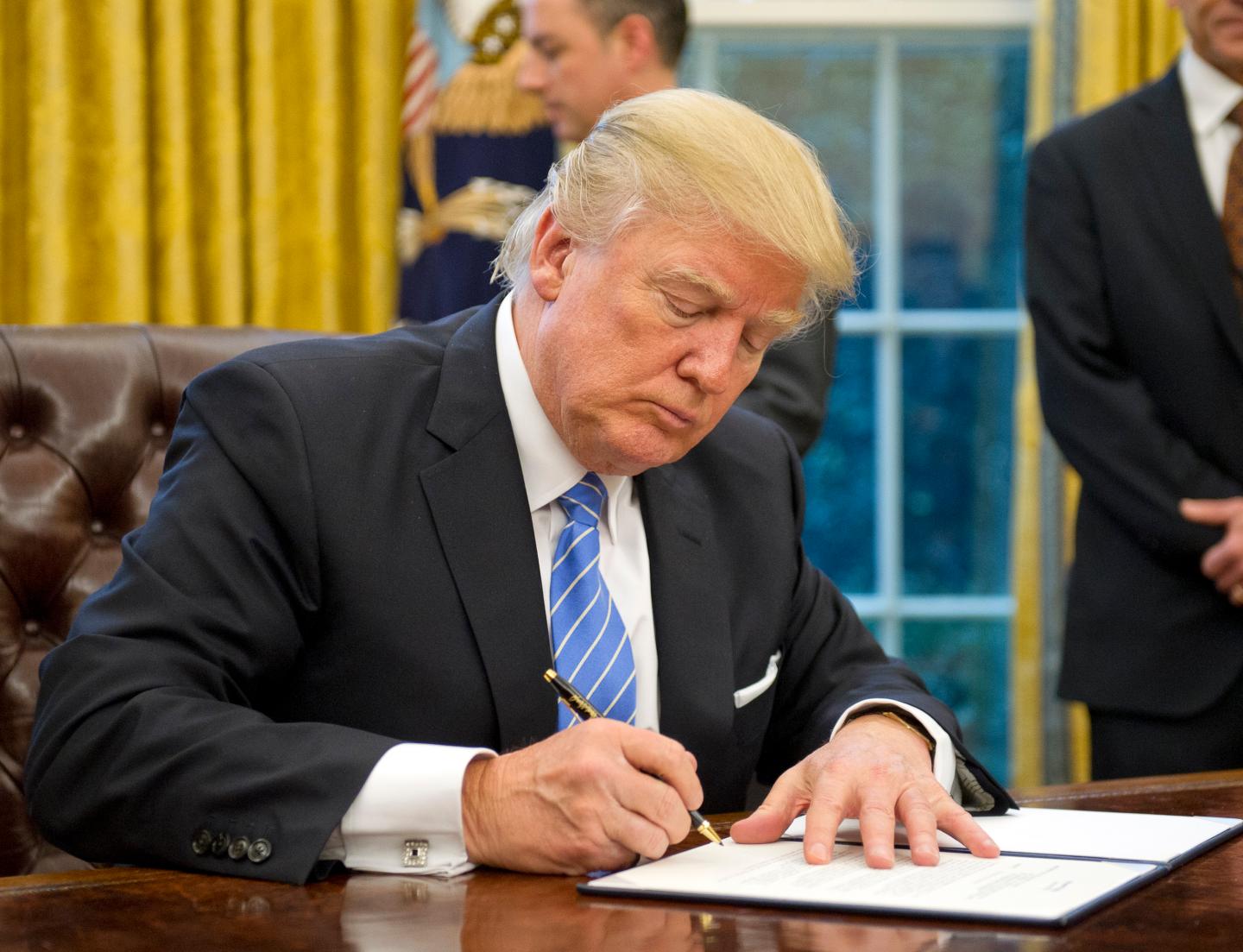 President Donald Trump signs the last of three Executive last January, which included the withdrawal of the U.S. from the Trans-Pacific Partnership (TPP) and a U.S. Government hiring freeze for all departments but the military.