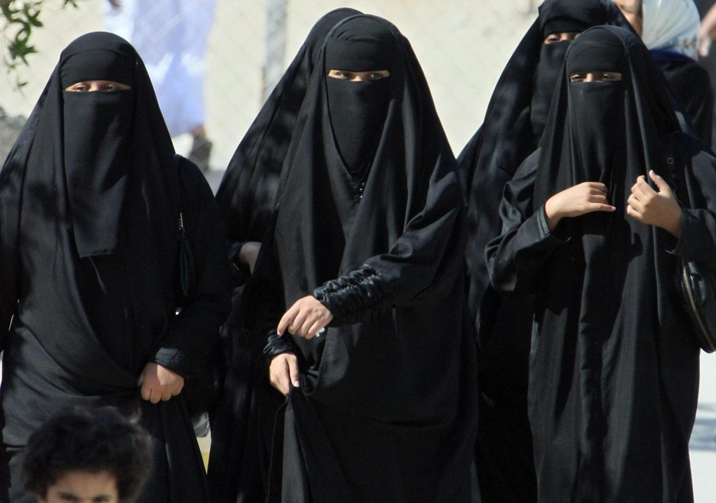 Saudi women cross a street in Hofuf city