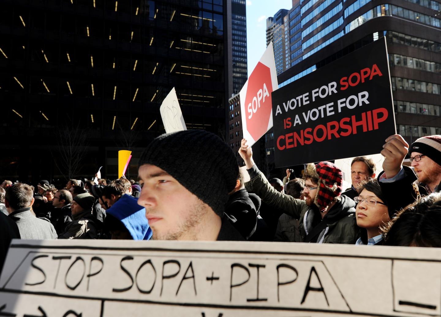 A man holds a sign at a protest by the t