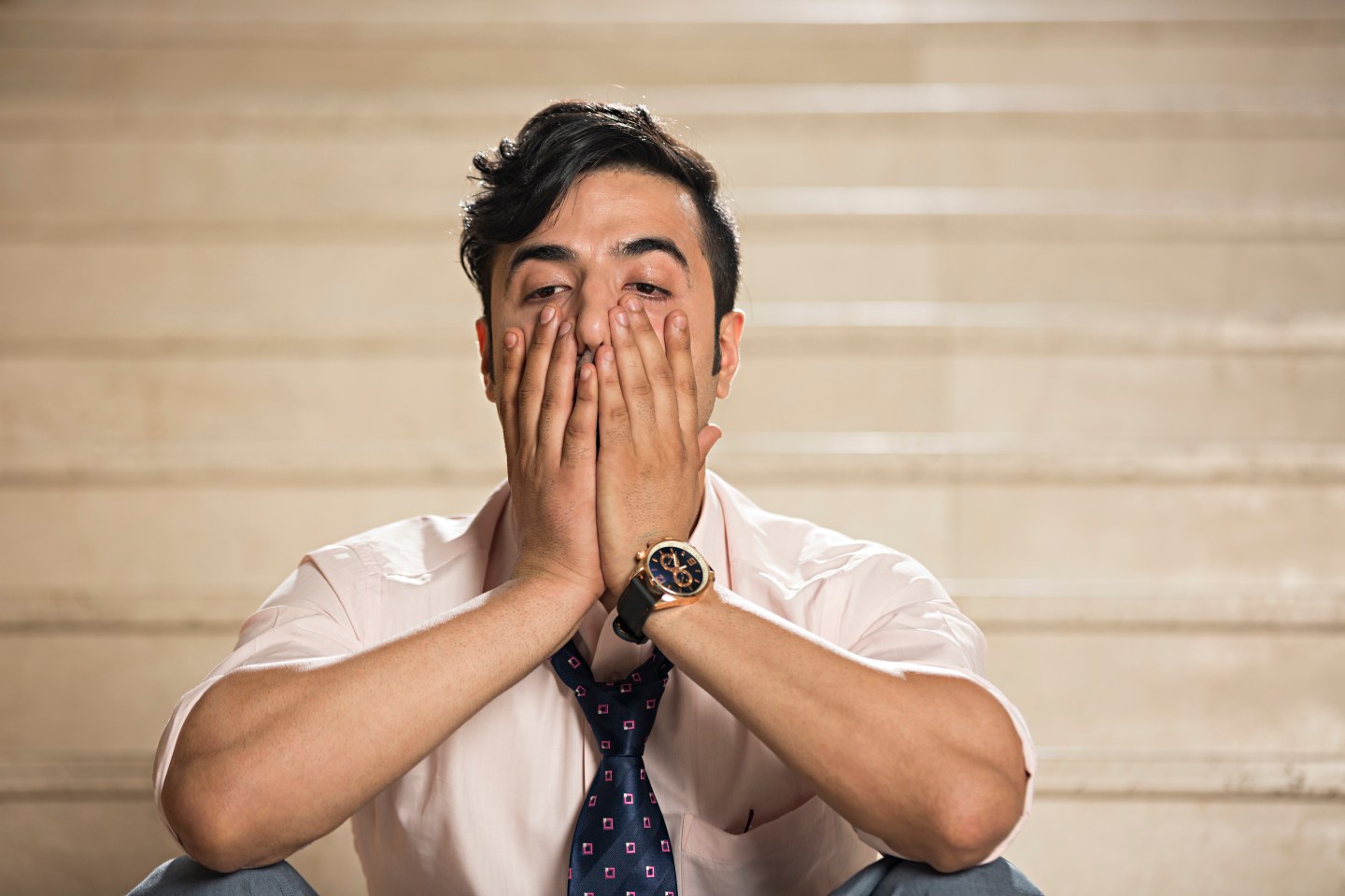 Businessman sitting on staircase with failure expression