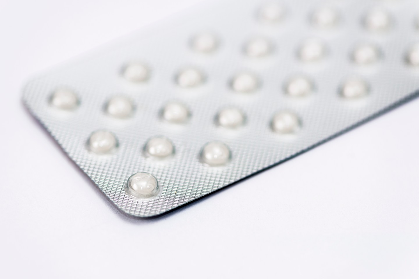 A silver foil strip with white medicine tablets, displayed
