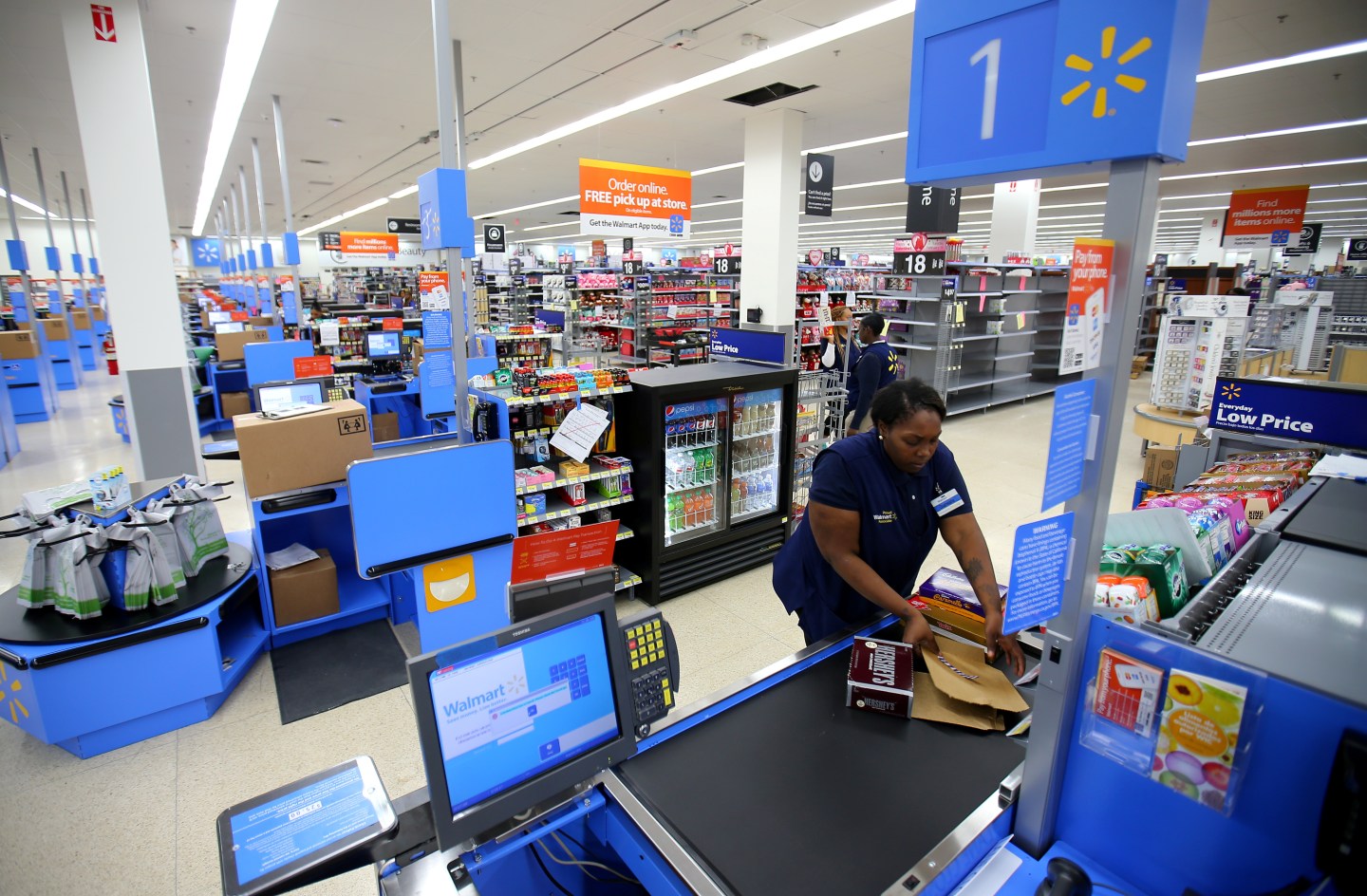 A worker prepares the check-out area at a newly built Walmart Super Center prior to its opening in Compton, California