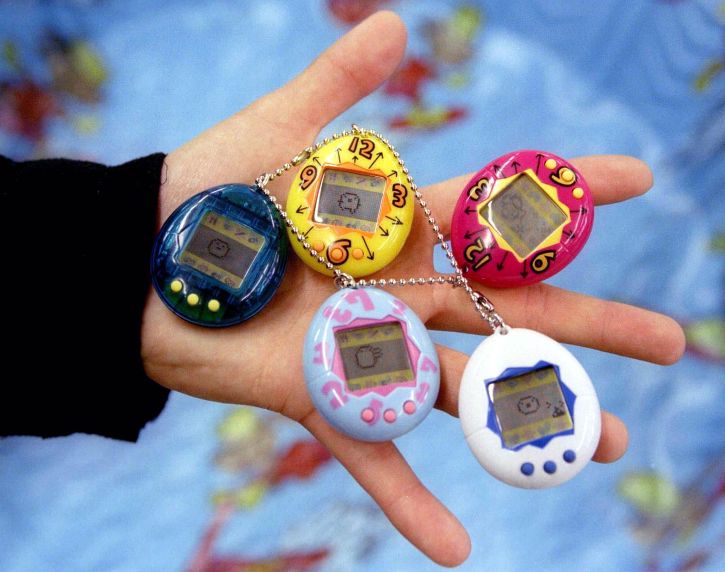A shop assistant holds some of the first Tamagotchi electronics 'pets' to arrive in Britain at a north London toy store May 8, 1997.