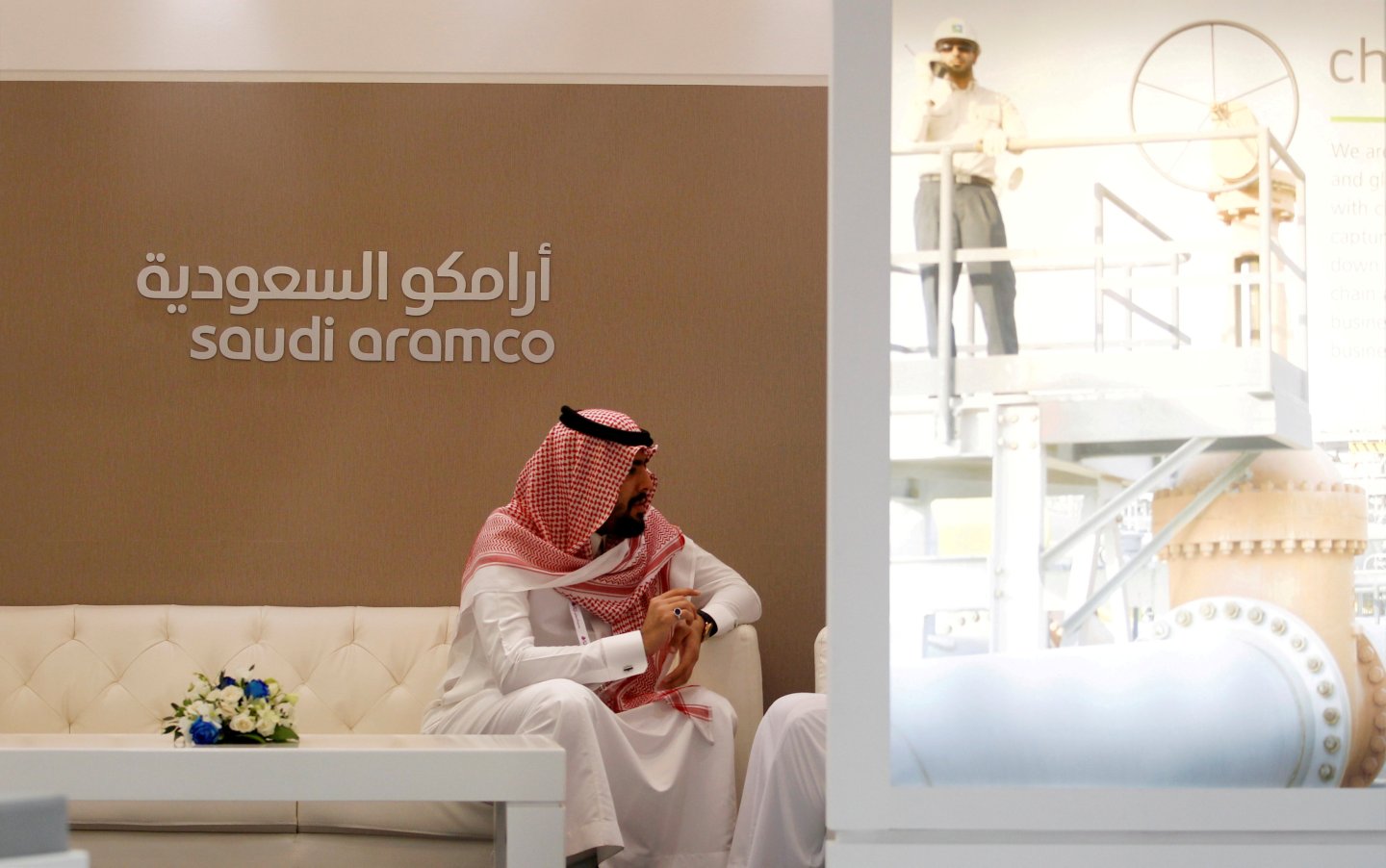 FILE PHOTO: A Saudi Aramco employee sits in the company stand at the Middle East Petrotech 2016 in Manama