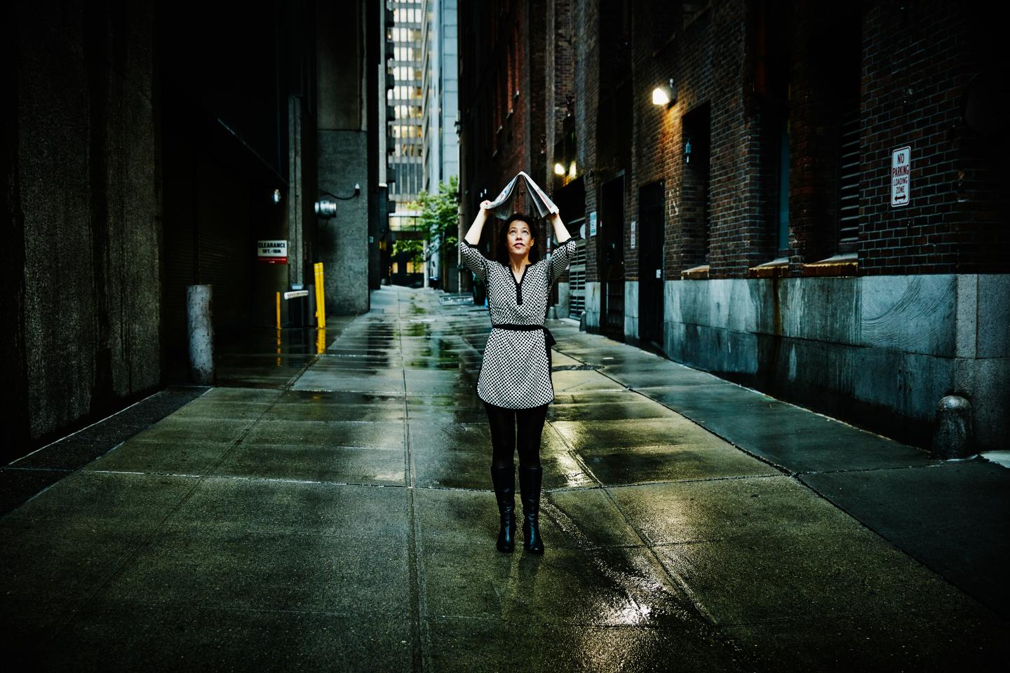 Businesswoman using newspaper for rain protection