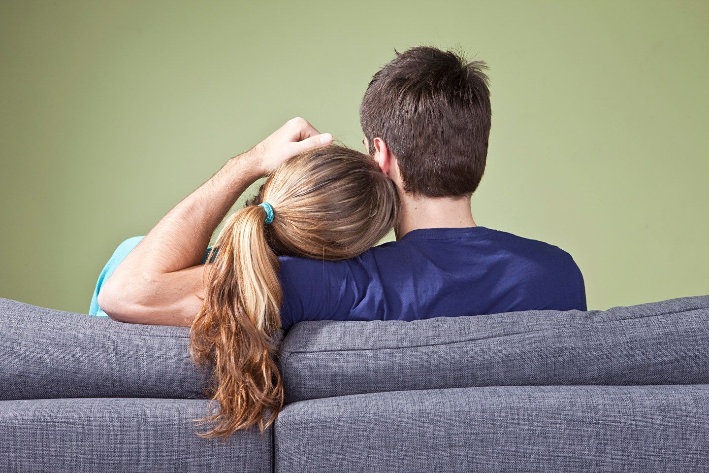 Young couple resting on couch, rear view