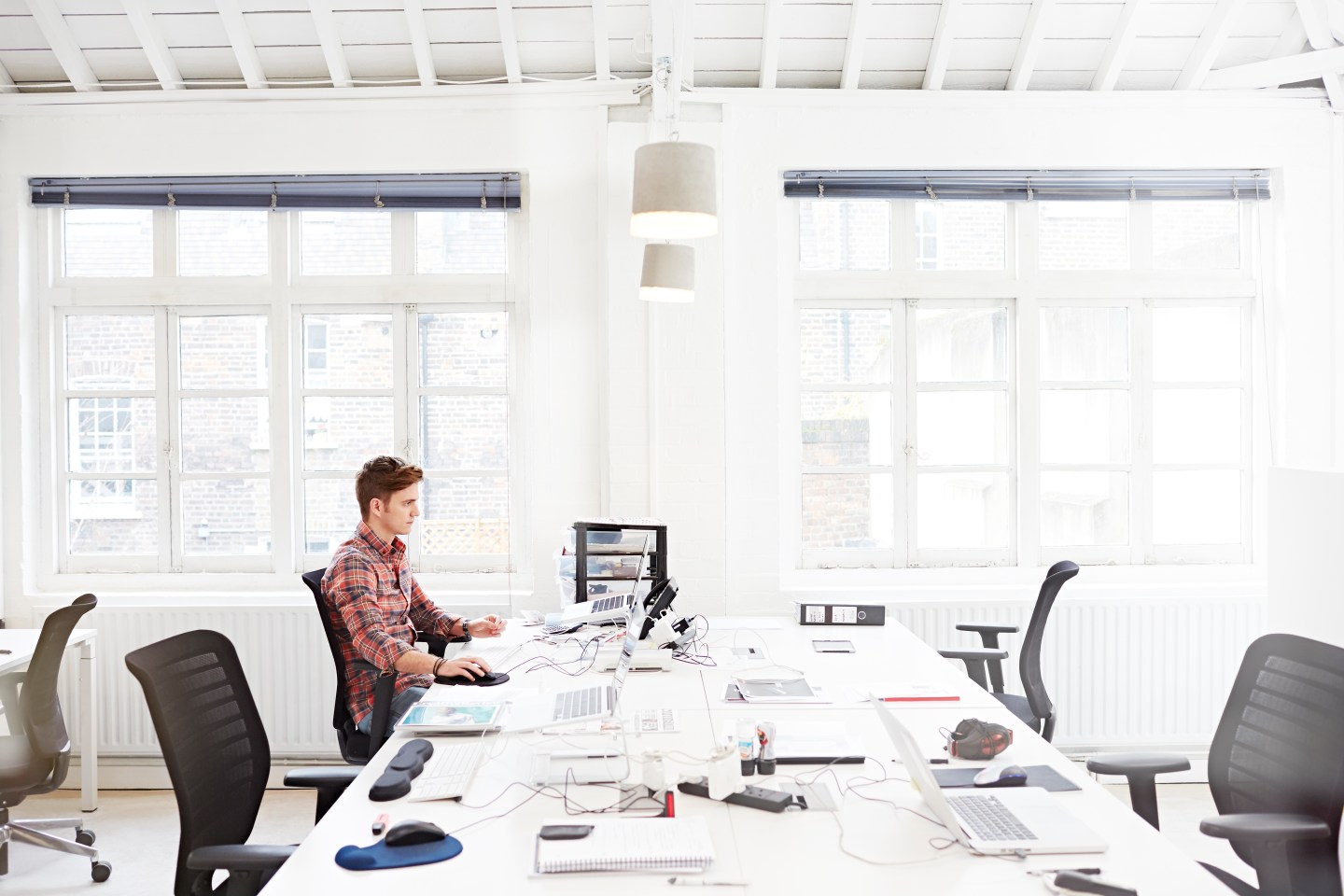 Young employee working in modern open plan office.