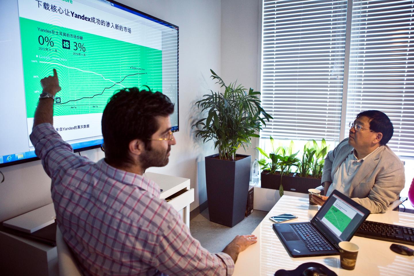 Founder of the ZhenFund seed fund Xu  listens to Israeli high-tech firm ironSource's CEO Bar Zeev during a presentation in Tel Aviv