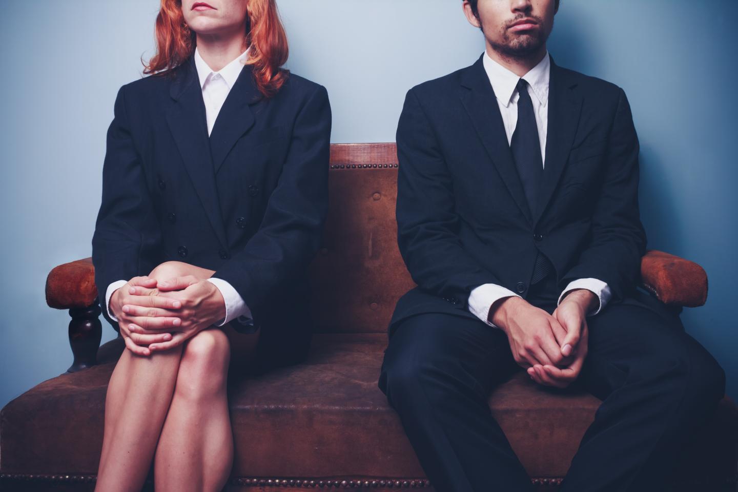 Businessman and woman waiting on sofa in lobby