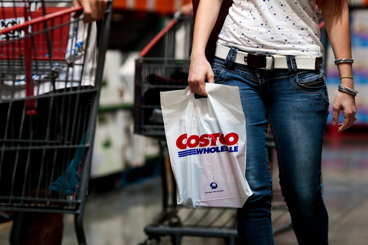 A customer carries a shopping bag inside a Costco Wholesale Corp. store in Miami, Florida, U.S., on Monday, Dec. 5, 2016.
