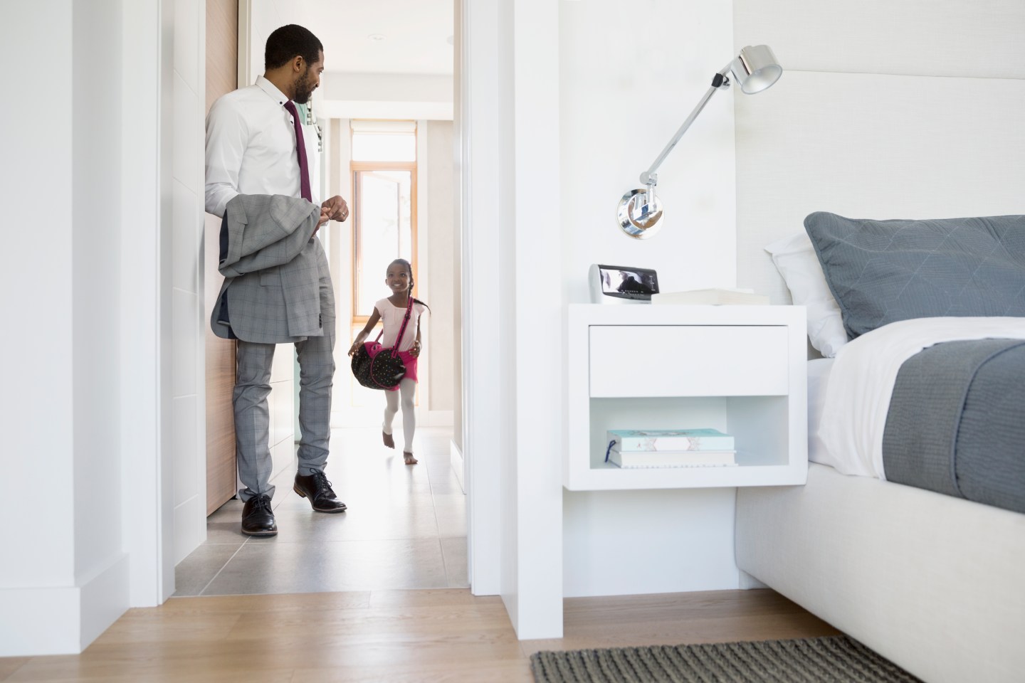 Father and daughter preparing to leave in morning hallway