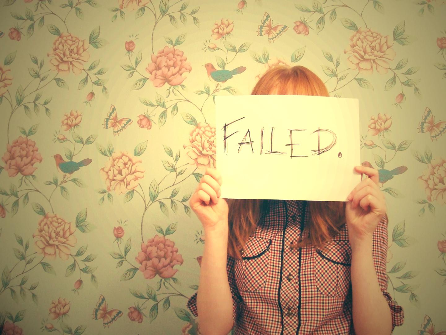 Girl holding failed text in front of her face