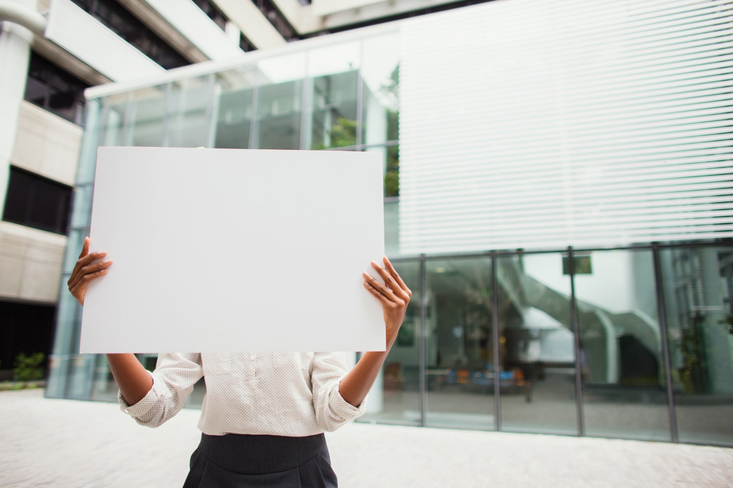 Businesswoman holding cardboard outside of office building