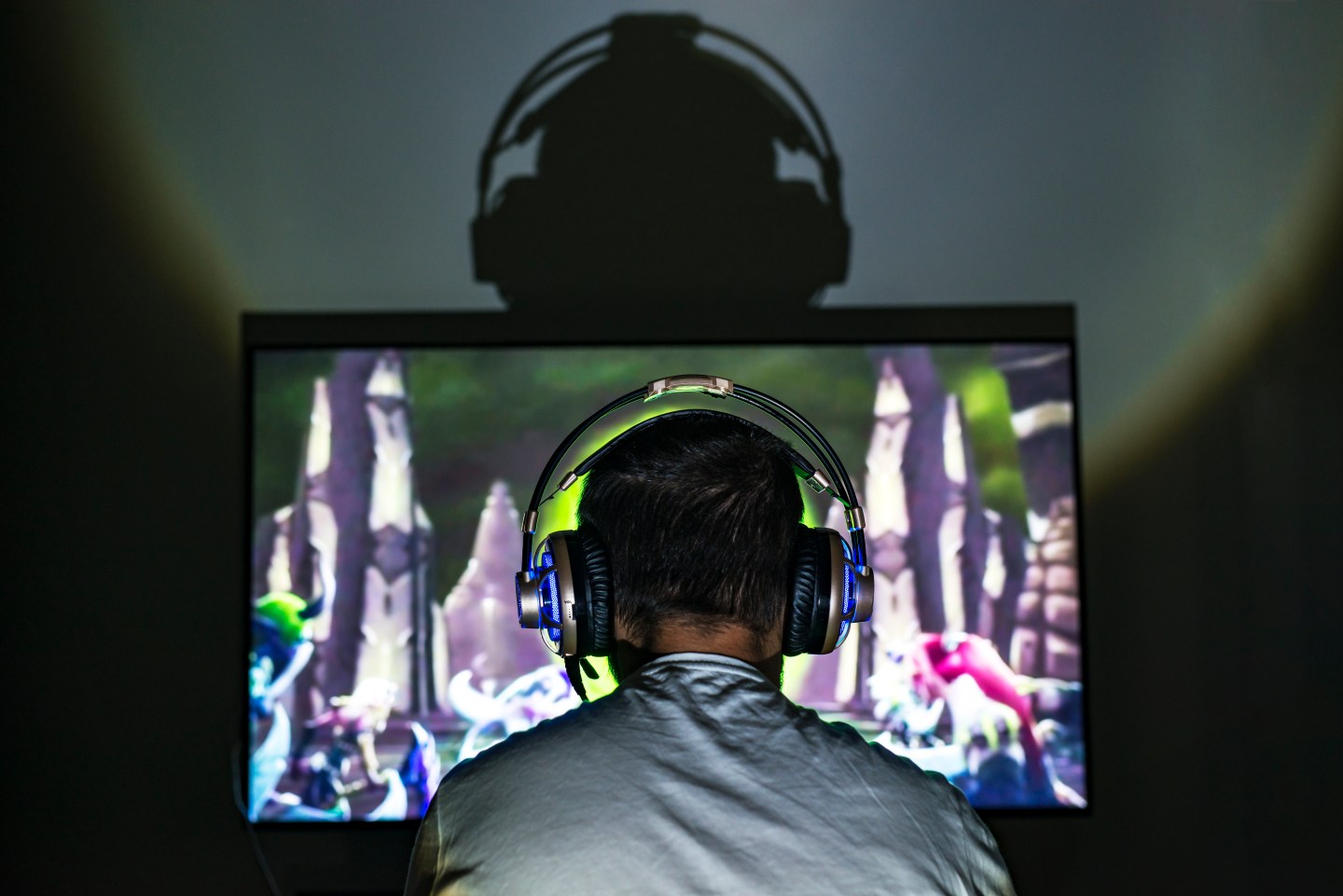 PC gamer playing video game wearing headphones.