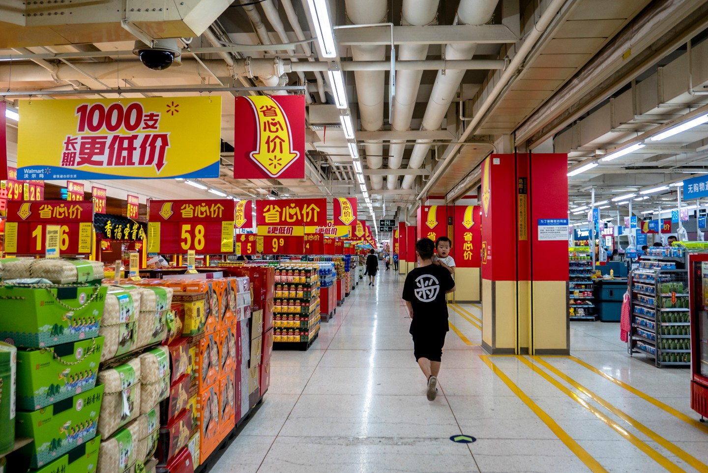 A father hugging his son walks in a Walmart supermarket.