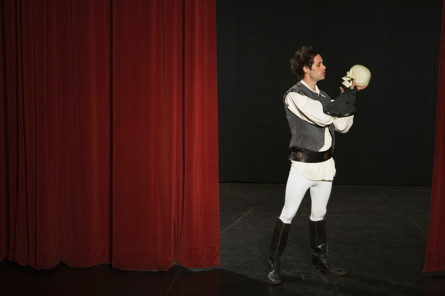 Actor holding skull on stage