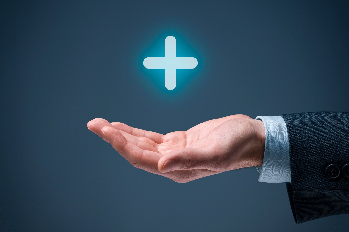 Cupped hand with a glowing plus symbol hovering above
